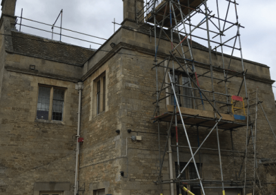 Scaffolding access tower with roof edge protection handrail.